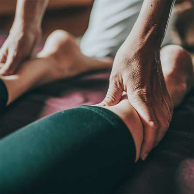 Sports massage practitioner working on a client
